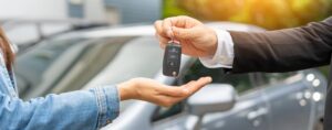 Car salesperson handing keys over to a customer.